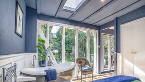 Un bagno moderno con una vasca freestanding, un'ampia finestra e vista sull'esterno.