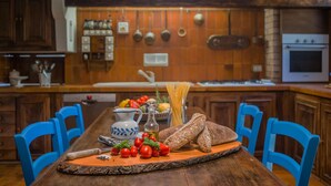 Une cuisine avec des meubles en bois, un îlot central et des chaises bleues.