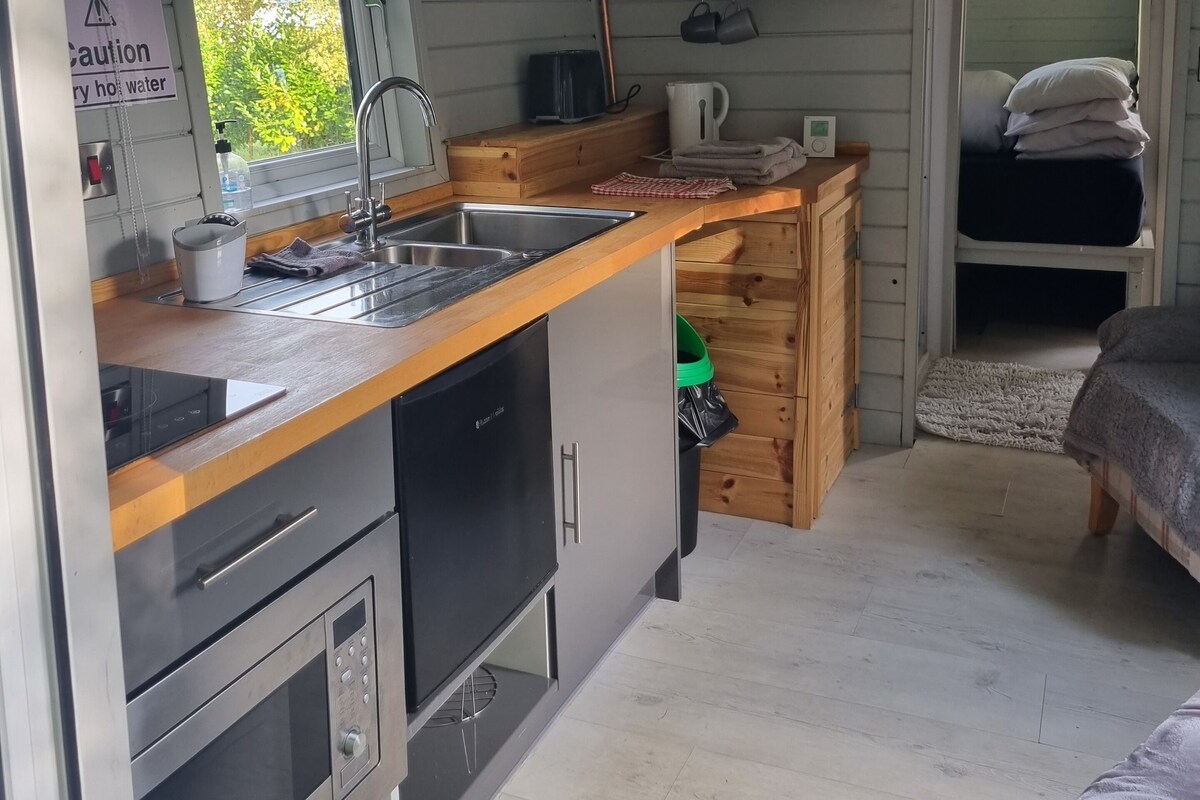 Una cocina funcional con lavabo, estufa y armarios de madera.