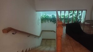 A staircase with a wooden handrail and a black chair in the foreground. - A Morada de Julia (Morgadans-Gondomar)