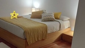 A bedroom with a bed, bedside tables, a nightstand, a lamp, and a star decoration. - A Morada de Julia (Morgadans-Gondomar)