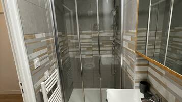 Een douche, een haardroger, zeep, toiletpapier