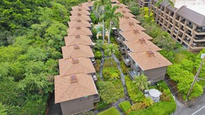 A hotel with multiple buildings, each featuring a rooftop terrace with a wooden deck and a pool.