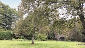 A well-maintained lawn with a single tree and a stone bridge in the background. - 3 bedroom accommodation in Enochdhu, near Pitlochy (Enochdhu, near Pitlochy)