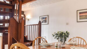 A dining table set with plates, glasses, and a vase with flowers. - The Coach House - UK41070 (Wootton, near Ryde)