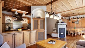 A spacious kitchen with wooden cabinets, a built-in stove, and hanging pendant lights. - Landhotel Schwab Ferienhaus (Schwarzach am Main)
