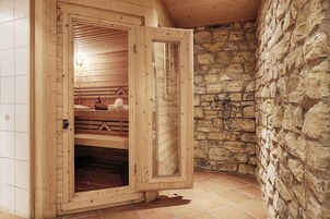 Una sauna con paredes de madera y una pared de piedra.