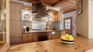 A kitchen with wooden cabinets, a stainless steel range hood, and a bowl of lemons on the counter. - Landhotel Schwab Ferienhaus (Schwarzach am Main)