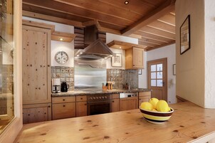 Una cocina con armarios de madera, una campana extractora de acero inoxidable y un tazón de limones en la encimera.