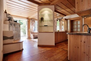 Una cocina amplia con pisos de madera, una isla central y una estantería con puertas de vidrio.