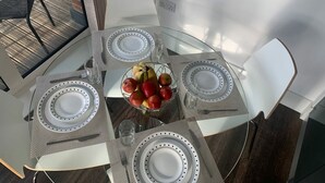 A dining table with four chairs, a fruit bowl, and a glass of water. - Luxury 2-Bed High-rise Apartment with beautiful view near Excel, &O2. Next to CR (London)