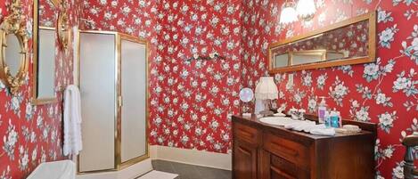 A bathroom with a toilet, bidet, and vanity with a mirror and towel rack.