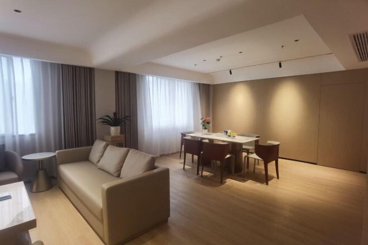 A modern living room with a sofa, dining table, and chairs.