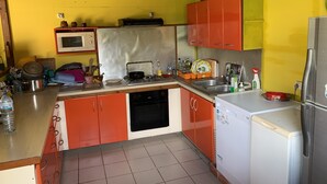 Cuina compacta amb microones, fogó, rentapeus i nevera petita.