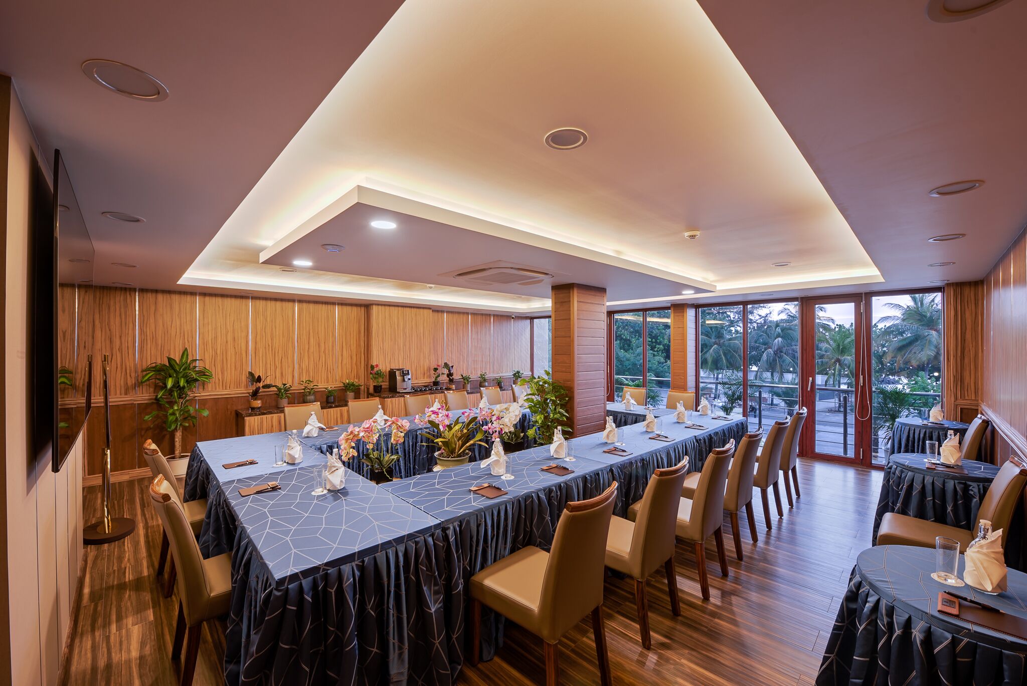 Un comedor amplio con una mesa larga dispuesta para una comida, rodeada de sillas.
