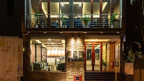 A two-story building with a ground-floor restaurant and a second-floor balcony with plants. - Summer Beach Maldives (Malé)