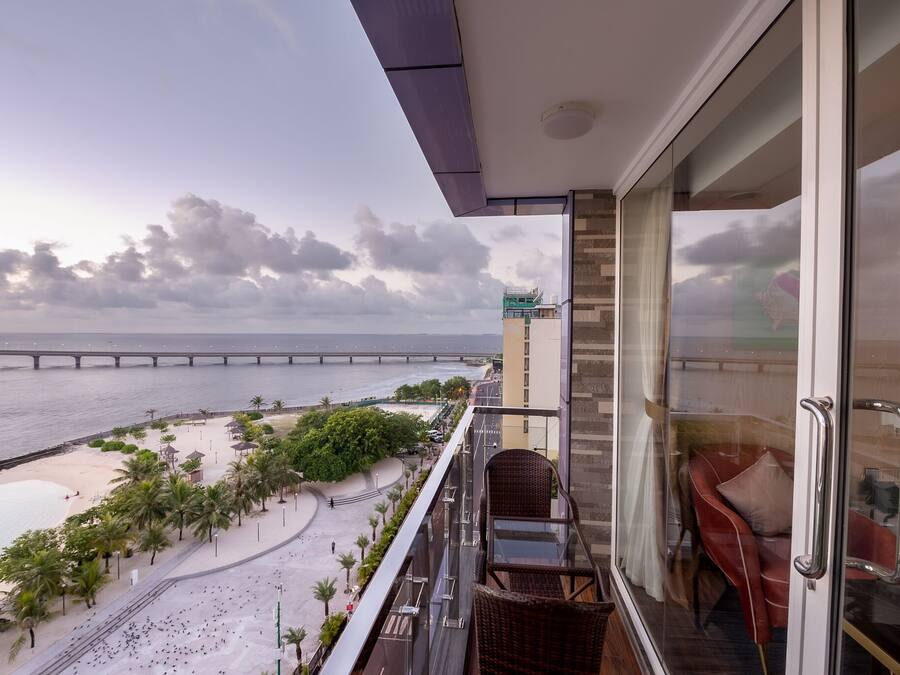 Een balkon met uitzicht op het strand en een brug.