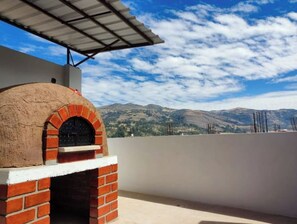 Enjoy a meal prepared in the outdoor oven on the rooftop terrace with a view of the surrounding landscape.