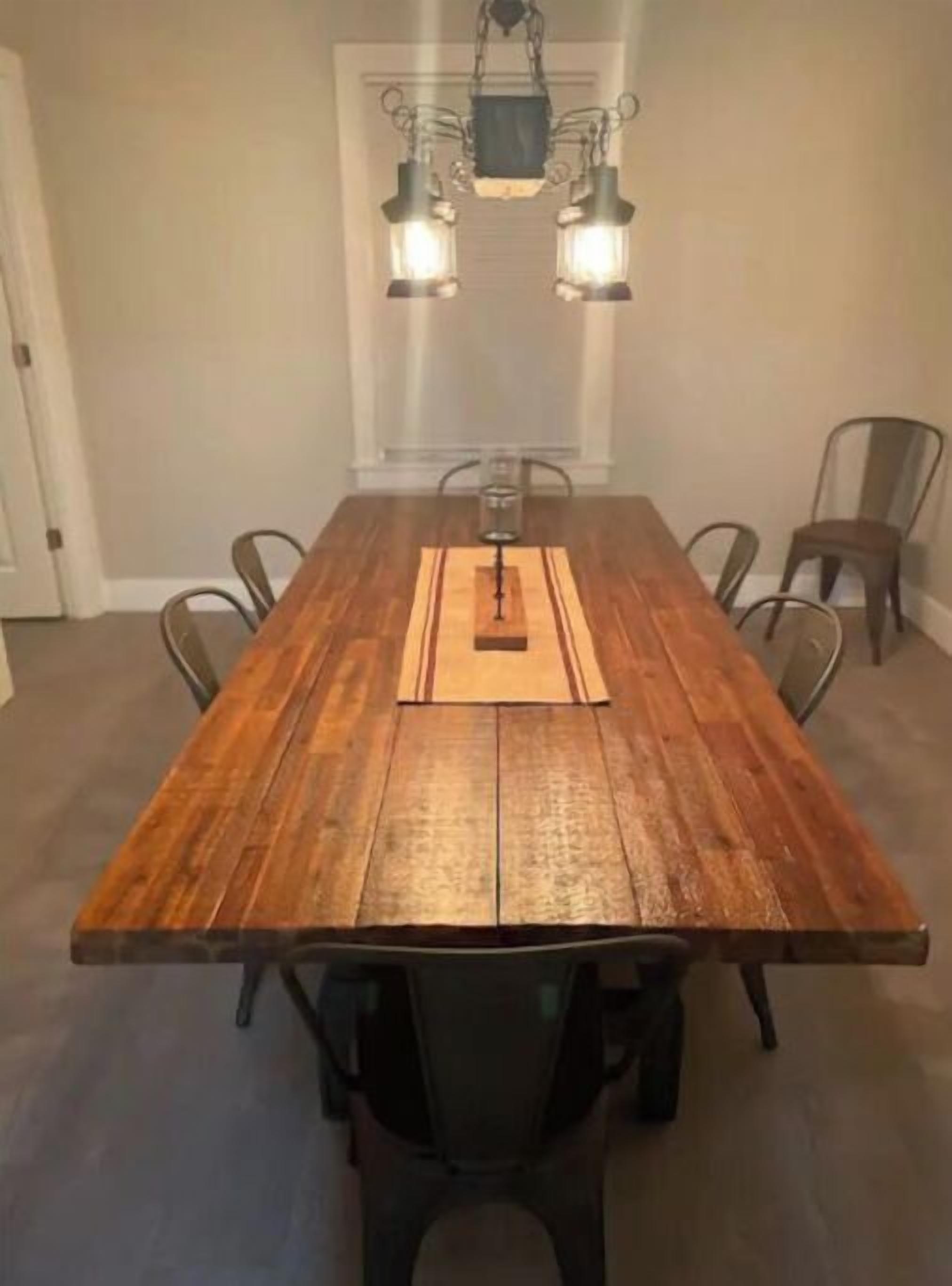 A wooden dining table with a central candle holder, surrounded by six chairs.