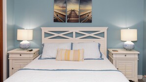 Ein Schlafzimmer mit einem Bett, zwei Nachttischen, einer Kopfteil und einem Wandbild.