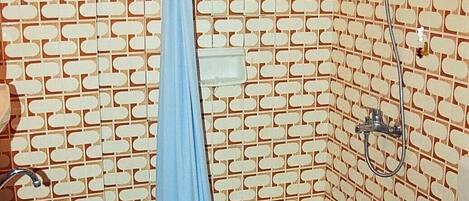Une salle de bain avec un mur à motifs, une douche, des toilettes et un lavabo.