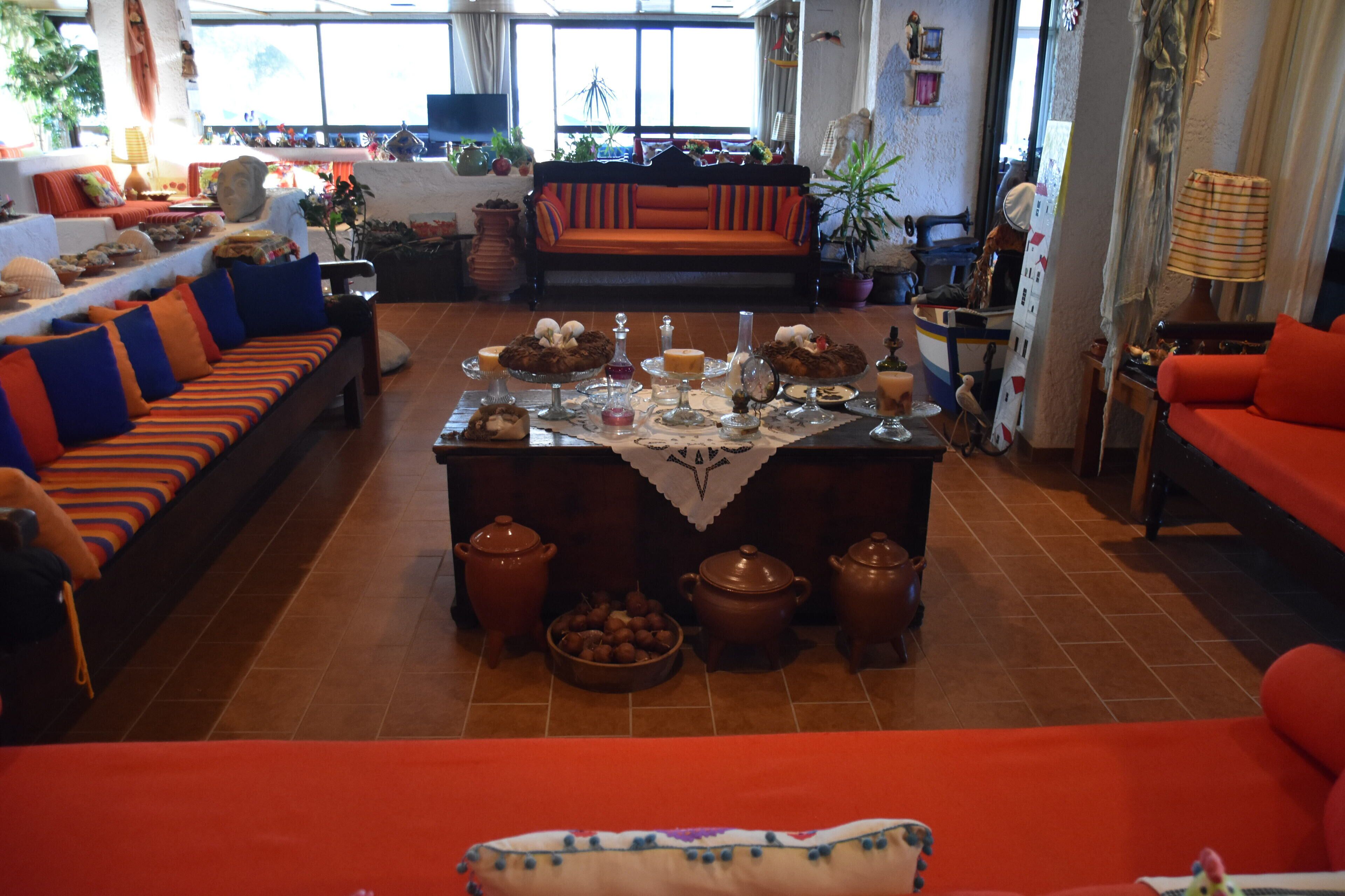 Amplio salón con una mesa de centro, sofás y un comedor con suelo de baldosas.