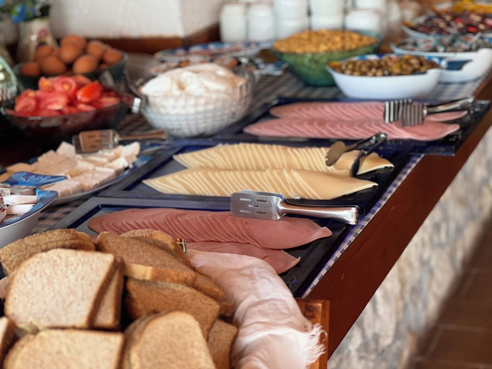 Un buffet proposant une variété d’aliments, notamment du pain, du fromage et de la charcuterie.