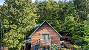 A cabin with a balcony, surrounded by dense forest. - Spacious Cabin 15 min to Dollywood w/Hot Tub, Game Room, Valley Views (Sevierville)