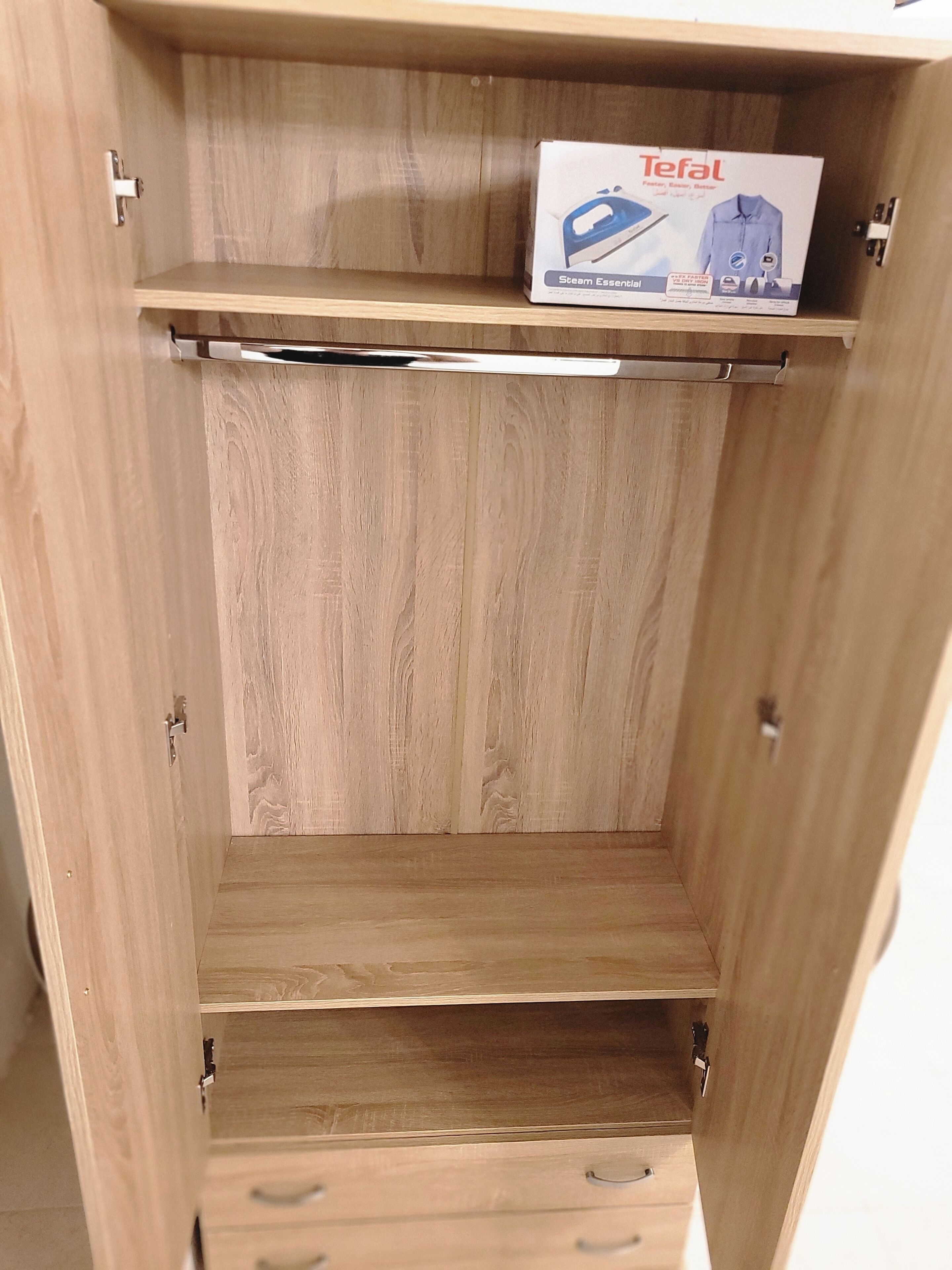 A wooden wardrobe with two drawers and a shelf.