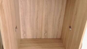 A wooden wardrobe with two drawers and a shelf.