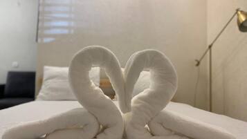 Una cama con una toalla dispuesta en forma de corazón.