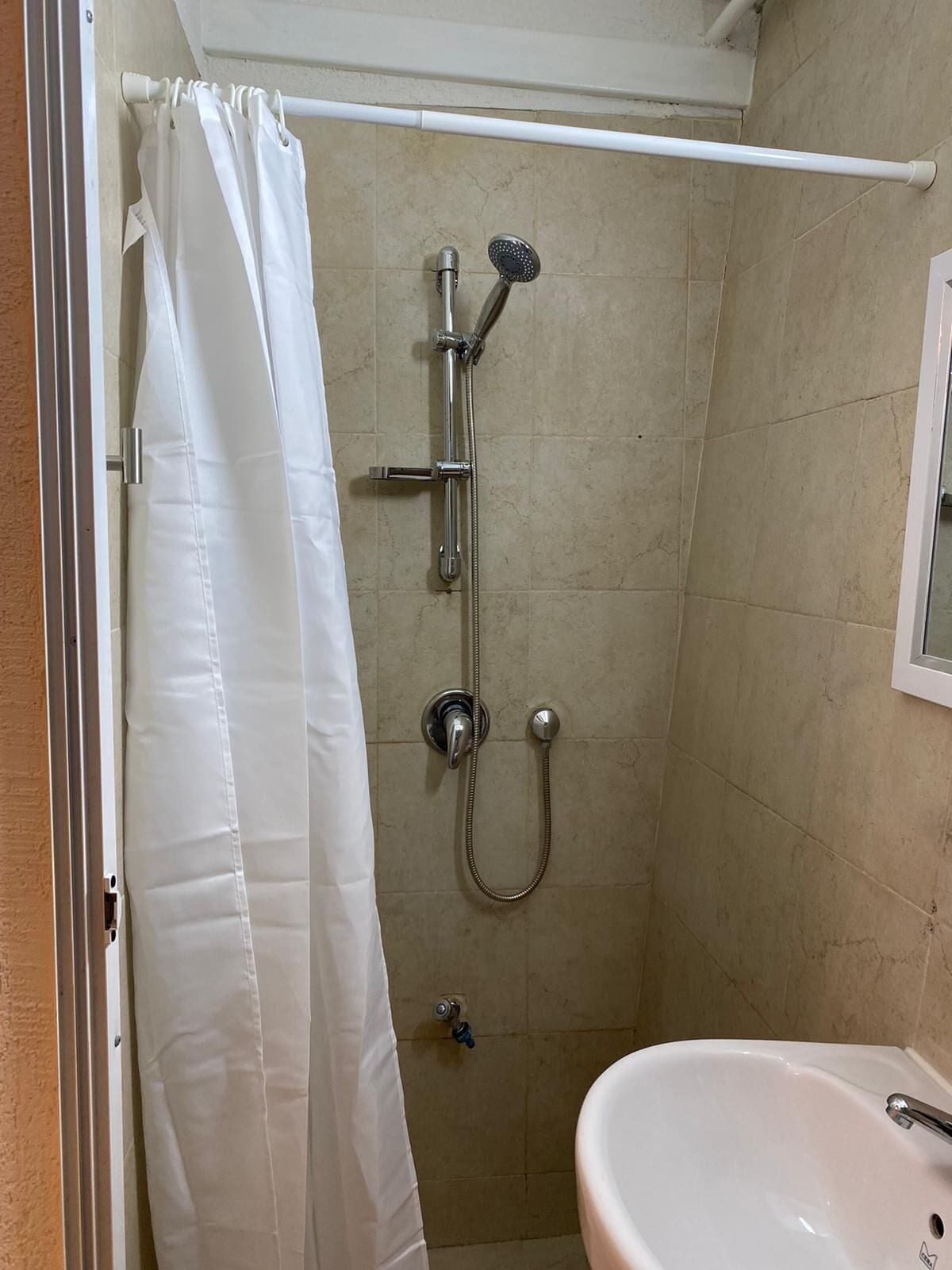 A bathroom with a shower, a sink, and a toilet.