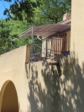 Enjoy the view from this balcony with a metal railing, offering a shaded retreat.