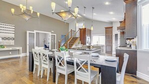 A spacious kitchen with a central island, wooden cabinets, and pendant lighting. - Grovenor. Sleeps 14. Family Home. Triple Garage. (Edmonton)