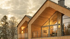 A modern wooden cabin with large windows and a balcony. - Korona Bieszczad Premium Apartments (Cisna)