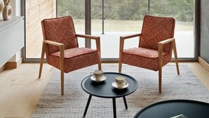A modern room with a large window, two patterned chairs, a small table, and a view of a mountainous landscape. - Korona Bieszczad Premium Apartments (Cisna)