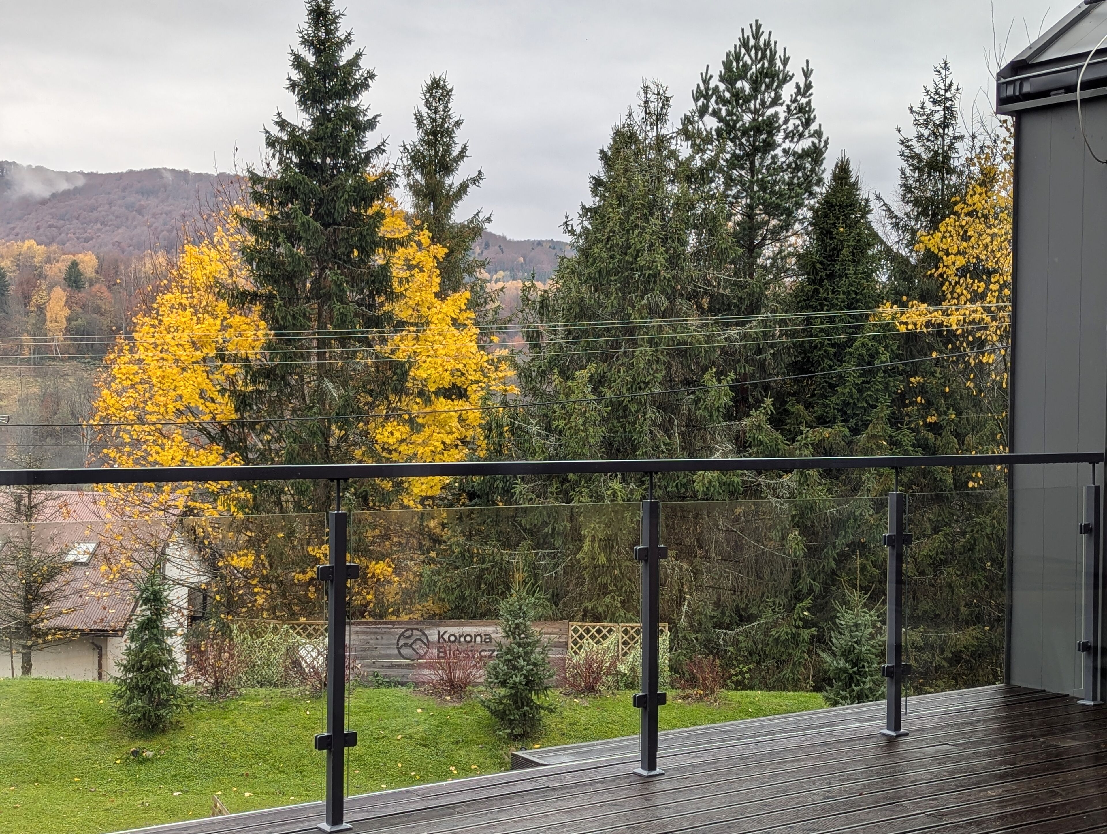 A balcony with a view of a forest and mountains.