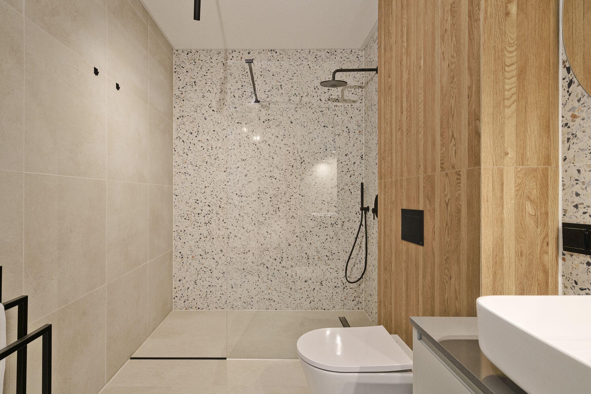 A modern bathroom with a shower, toilet, and sink.