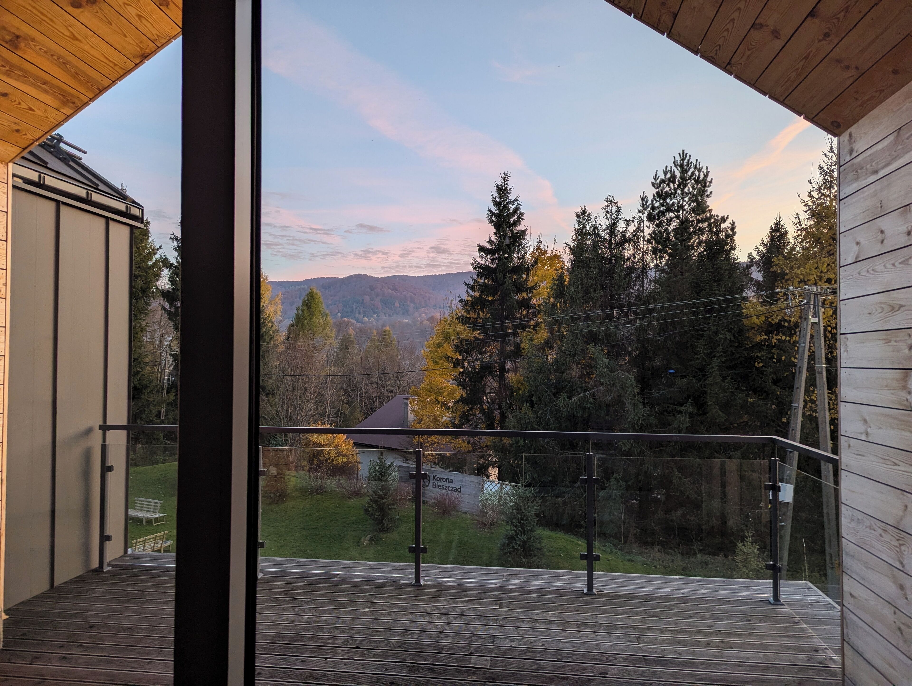 A balcony with a view of a forested area and mountains.