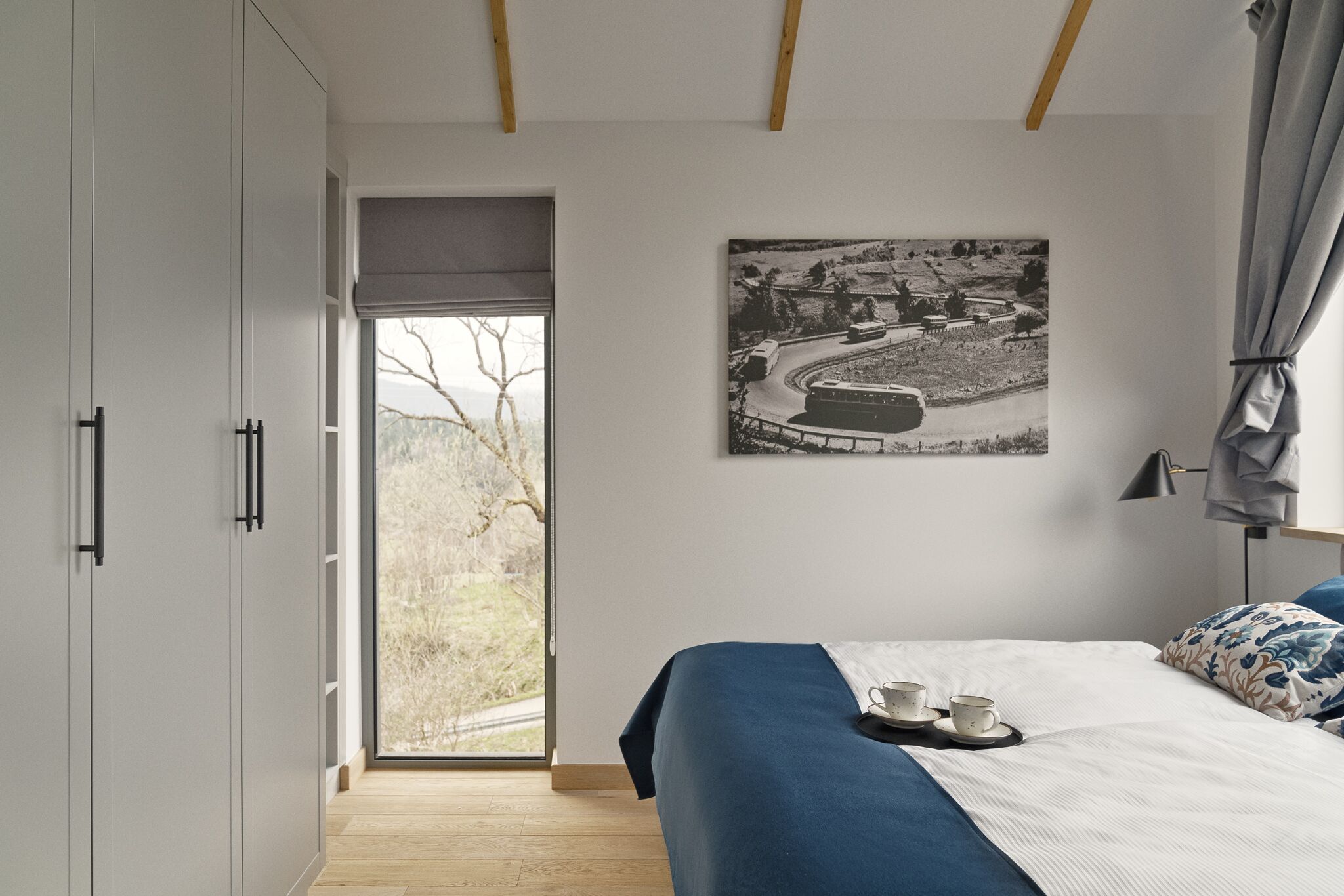 Un dormitorio con cama, ventana y puerta que da a un balcón.
