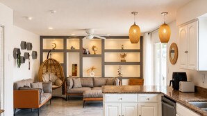 A modern kitchen with white cabinetry, a marble countertop, and a built-in dishwasher. - Tropical Vacation POOL Home in Melbourne, 7 mins to Beach (Melbourne)
