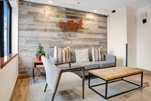 Relax in this stylish living room with a sofa, armchair, and coffee table, surrounded by a unique railroad station-inspired design.