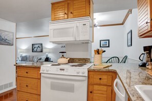 Kitchen area with central island, stove, and microwave, offering ample storage and workspace.