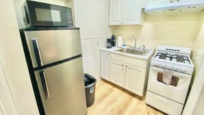 Une cuisine compacte équipée d’un réfrigérateur, d’un four à micro-ondes, d’un évier et d’une cuisinière.