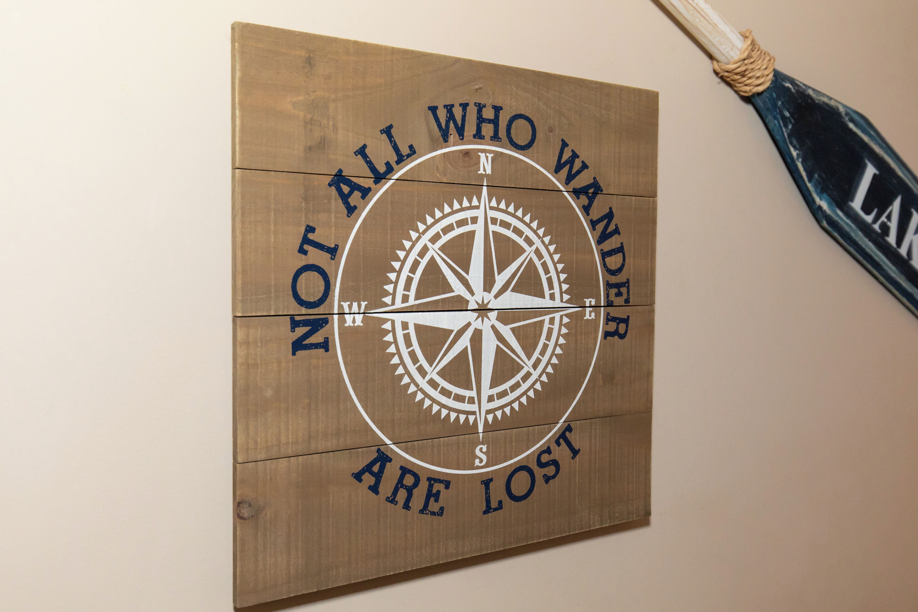 Un mur en bois orné d’une boussole et de l’inscription : « Tous ceux qui errent ne sont pas perdus. »