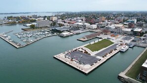 An aerial view of a marina with docks, boats, and a large building complex. - Condo with Lake & Cedar Point View (Sandusky)