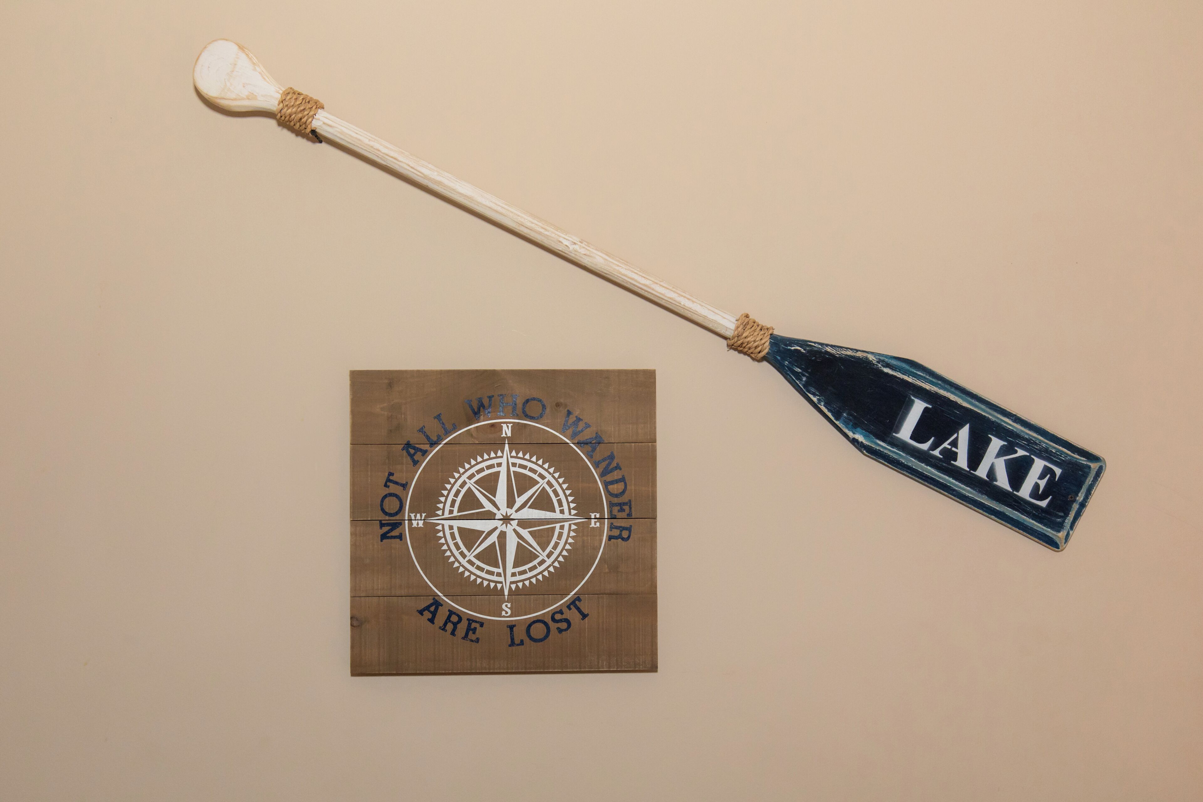 Een kompas en een bord met de tekst 'ALL WHO WANDER ARE LOST' en 'LAKE'.