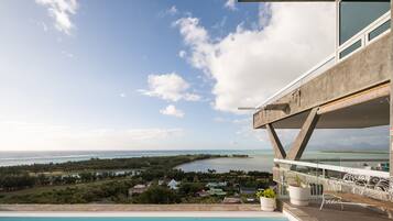 A modern building with a pool overlooking a coastal landscape.