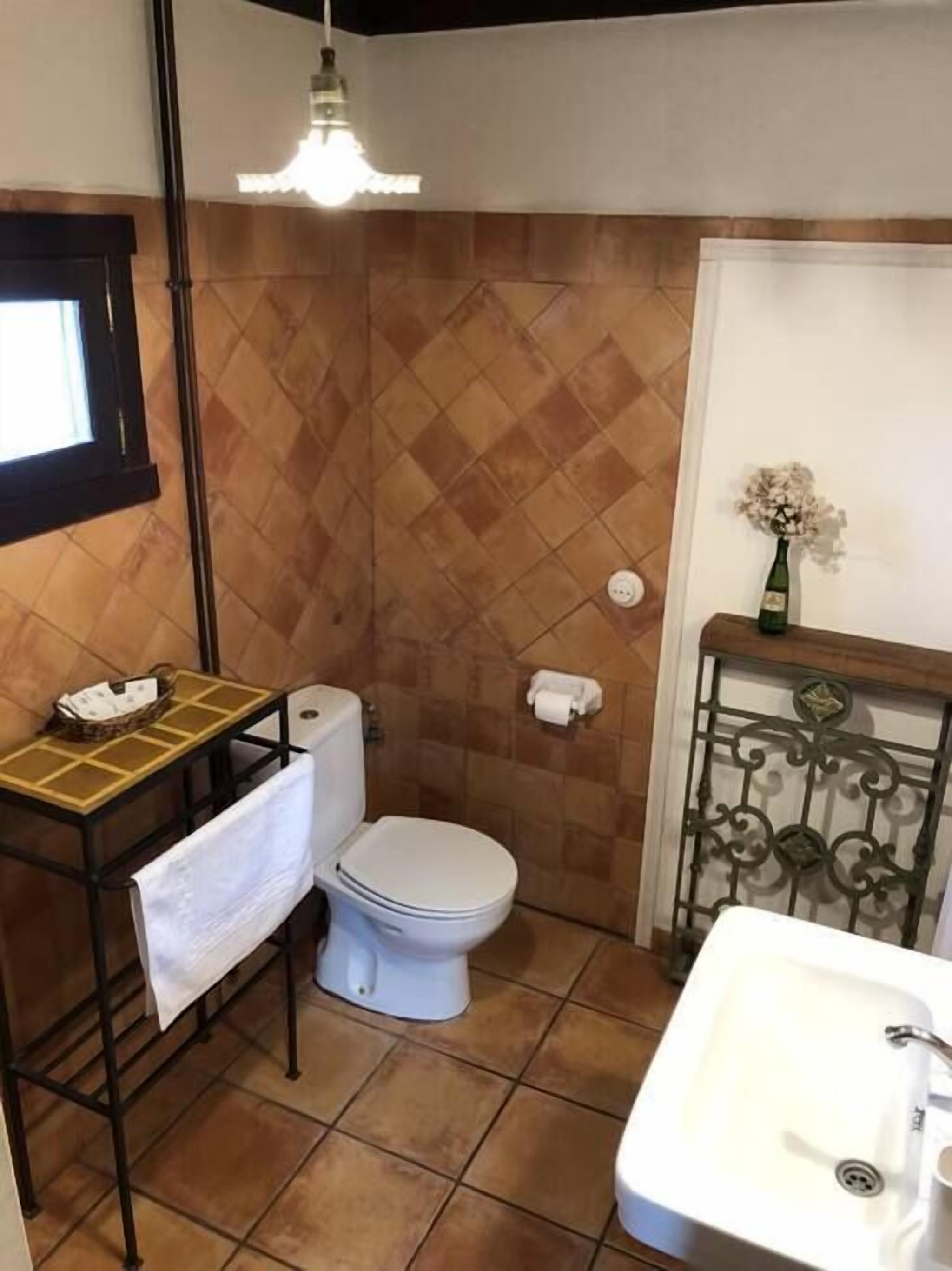A bathroom with a toilet, sink, and shower.