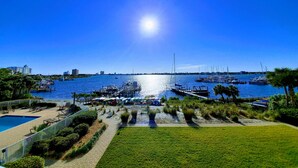 Een jachthaven met aangemeerde boten, een zwembad en een helderblauwe lucht.